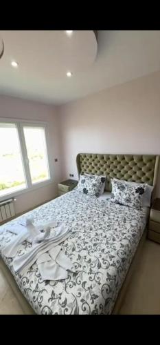 a bedroom with a large bed with a blanket and pillows at Exclusive luxury villa private pool and garden mnar in Tangier