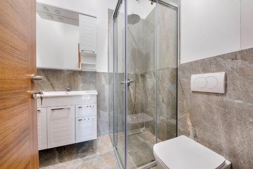 a bathroom with a shower and a toilet and a sink at ZIS LUX Sea View in Kravlja