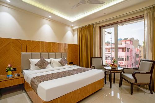 a bedroom with a bed and a large window at The Delhi Star Hotel near Connaught Place- New Delhi in New Delhi