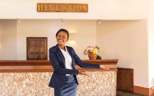 a woman standing in front of a reception desk at The ONE in Watamu
