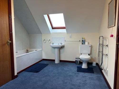 a bathroom with a sink and a toilet and a bath tub at Corrie View in Roybridge