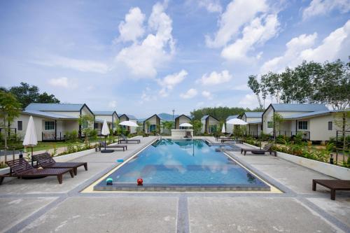 a pool at a resort with benches around it at NaraRin Phuket Resorts in Thalang
