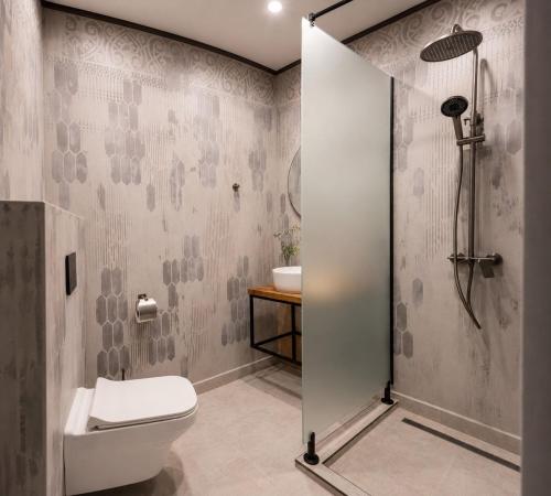a bathroom with a shower and a toilet and a sink at Комплекс Шампион in Kazanlŭk