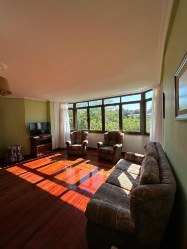 a living room with a couch and chairs and a large window at Apartamentos de la Hoz in Isla