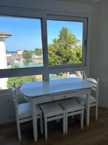 a table and two chairs in front of a window at Apartamentos de la Hoz in Isla