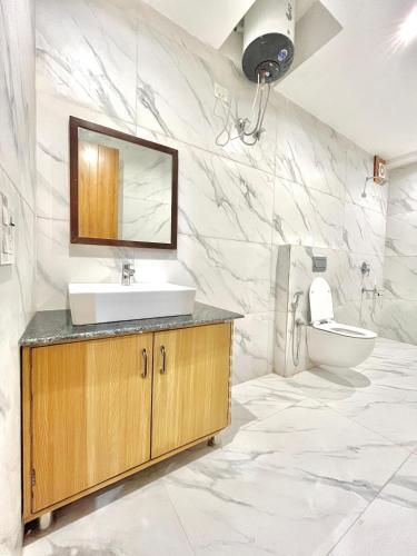 a bathroom with a sink and a toilet at The Royals Luxury Apartments Rooftop Restaurant Lift Live Music Sat in Kasauli