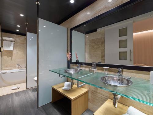 a bathroom with two sinks and a glass counter at H10 Marina Barcelona in Barcelona