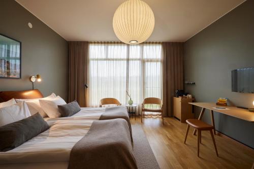a hotel room with a large bed and a desk at Barsebäck Resort Hotell in Löddeköpinge