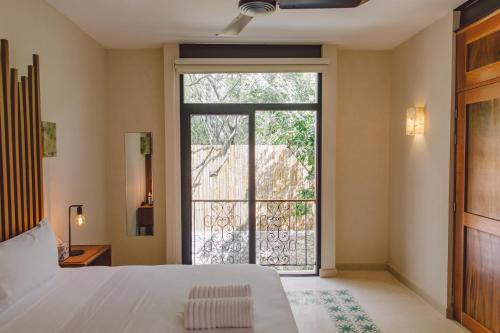 a bedroom with a bed and a large window at TreeHouse Boutique Hotel, an adults only boutique hotel in Mérida