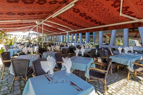a group of tables and chairs with blue table cloth at Hôtel Restaurant Au Cygne in Eschau
