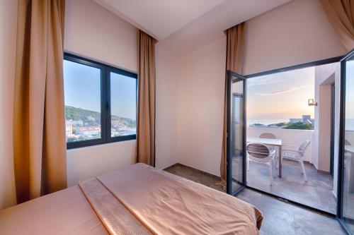 a bedroom with a bed and a table with a view at ZIS LUX Sea View in Kravlja
