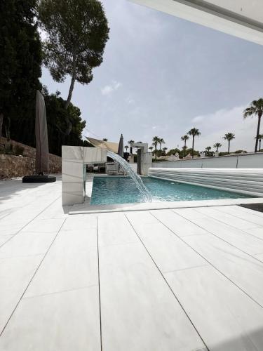 a swimming pool with a water fountain at Villa Capitan in Orihuela Costa