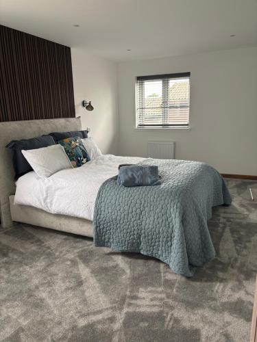 a bedroom with a large bed and a window at Swallows Lodge in Bathgate