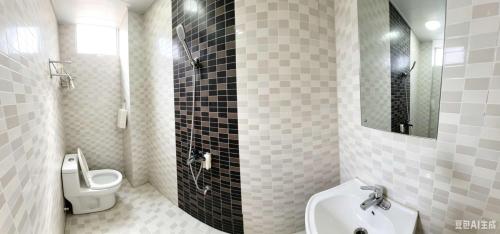 a bathroom with a toilet and a sink and a mirror at YangShuo Backpacker Hostel West Street Branch in Yangshuo