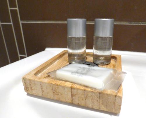 two bottles of water in a wooden tray on a counter at Hotel Akazienhof in Duisburg