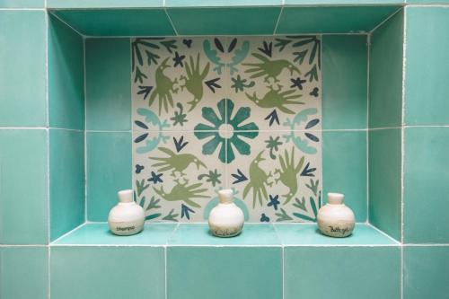 four white vases sitting on a shelf in a bathroom at TreeHouse Boutique Hotel, an adults only boutique hotel in Mérida