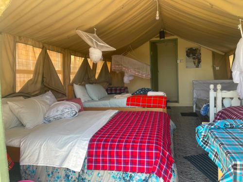 a bedroom with two beds in a tent at Treasure camp in Maasai Mara National Reserve