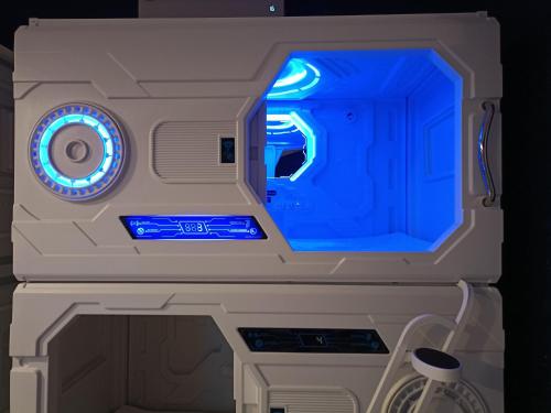 a machine with a blue light in a room at Galaxy Capsule Hotel near Hitech in Kulim