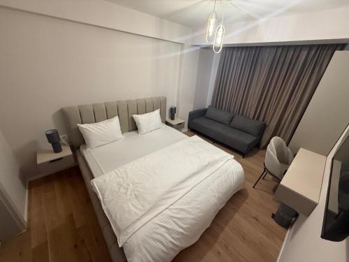 a bedroom with a white bed and a couch at Struga Lake Suites in Struga