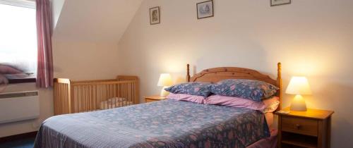 a bedroom with a bed and two lamps and a window at Eagles Ledge Cottage in Roybridge