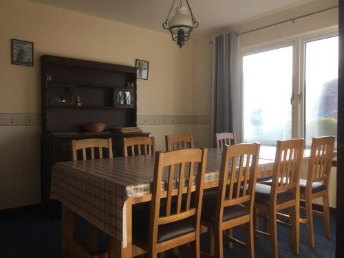 a dining room with a table and chairs and a window at Eagles Ledge Cottage in Roybridge