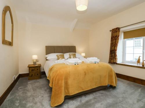 a bedroom with a large bed with a yellow blanket at Pete's Place in Taunton