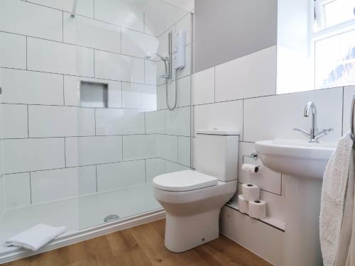 a white bathroom with a toilet and a sink at Pete's Place in Taunton