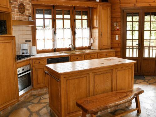 a kitchen with wooden cabinets and a stove top oven at Le coin de paradis in Bouvellemont