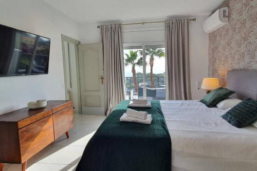 a bedroom with a bed and a dresser and a window at Opening Doors Premiá Dalt Amazing views w pool in Premia de Dalt