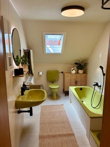 a bathroom with a yellow tub and a green sink at Ferienhaus Gramm in NuÃŸbaum