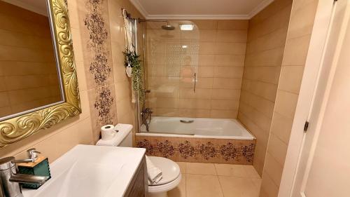 a bathroom with a tub and a toilet and a sink at Pasión Junto al mar in Calpe