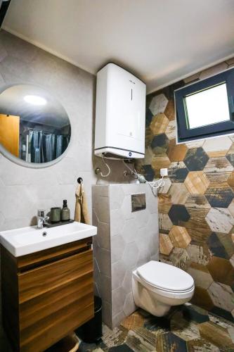 a bathroom with a toilet and a sink and a mirror at KosMy dream in Sopot