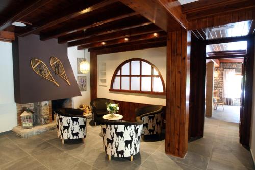 a living room with chairs and a table and a fireplace at Hotel & Spa Real Villa Anayet in Canfranc-Estación