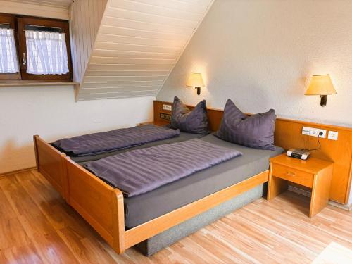 a bed in a room with two pillows on it at Hotel Garni KAMBEITZ in Ötigheim