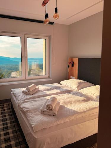 two beds in a room with two windows at Kazalnica Family&Conference Resort by Solarento in Karpacz