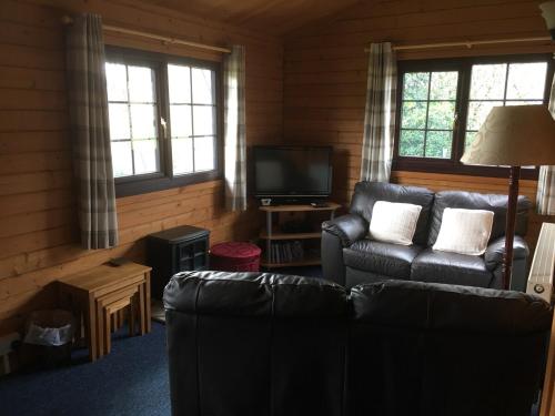 a living room with a couch and a television at Robins Nest in Roybridge