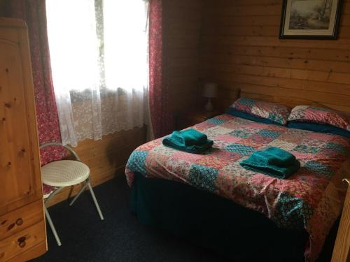 a bedroom with a bed with two green pillows on it at Robins Nest in Roybridge