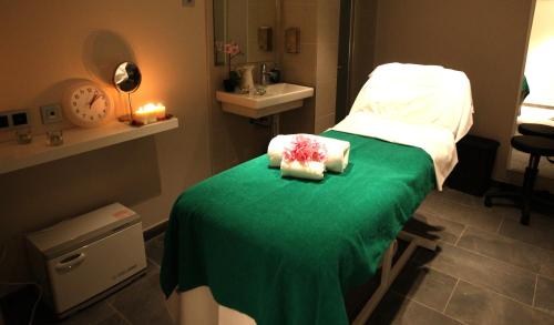 a hospital room with a bed with a green blanket at Hotel & Spa Real Villa Anayet in Canfranc-Estación
