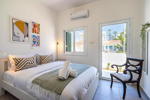 a bedroom with a bed and a chair and a window at Arty Haven - Spacious 3-BR House in Larnaca in Larnaca