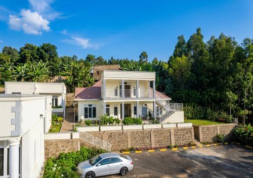 a house with a car parked in front of it at Choice Lounge in Rubavu