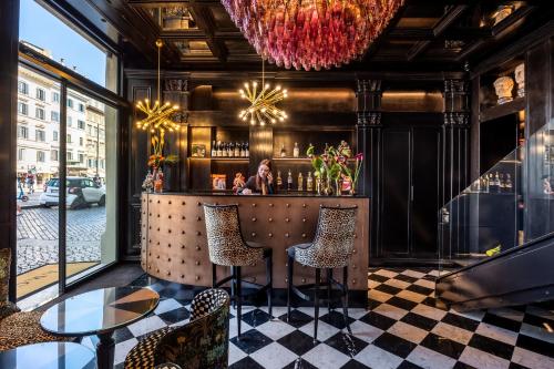 a restaurant with a bar with two chairs and a table at Argentum Boutique Hotel & SPA in Rome