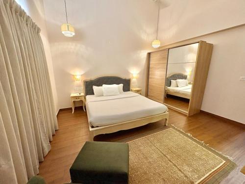 a bedroom with a bed and a large mirror at 3BHK Elegant Duplex Villa with Pool Access in Assagao