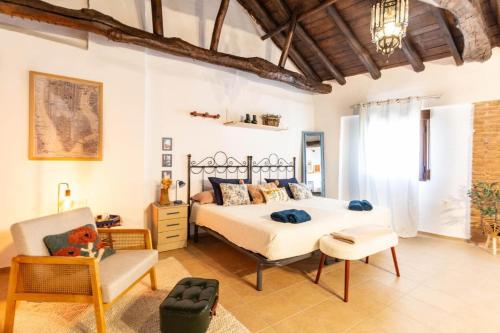 a bedroom with a bed and a chair at Casa Rubia Limón in Béznar