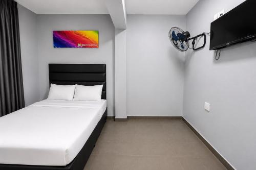 a bedroom with a white bed and a tv at Metro Lodge MP in Durban