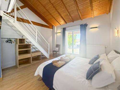 a bedroom with a large bed and a staircase at DOMAINE DE LA PORTE in Agonac