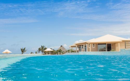 a villa with a swimming pool in front of a house at The ONE in Watamu