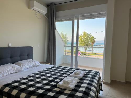 a bedroom with a black and white checkered bed with a window at Thalassa View VB2 in Khalkoútsion
