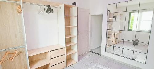 a walk in closet with a glass door at Jolie villa avec piscine chauffée proche du lac in Sanguinet
