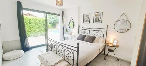 a bedroom with a bed and a toilet and a balcony at Jolie villa avec piscine chauffée proche du lac in Sanguinet