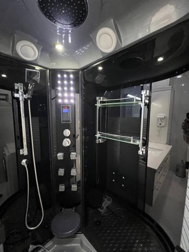 a bathroom with a shower and a toilet and a sink at Gardence Residence Suite in Tashkent
